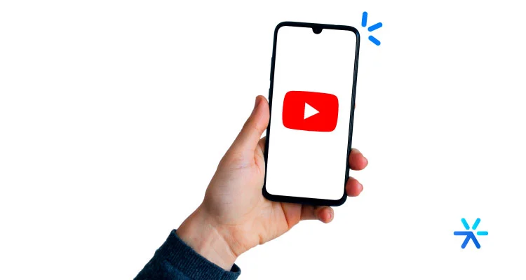 Mão segurando celular com logo do Youtube dentro. 